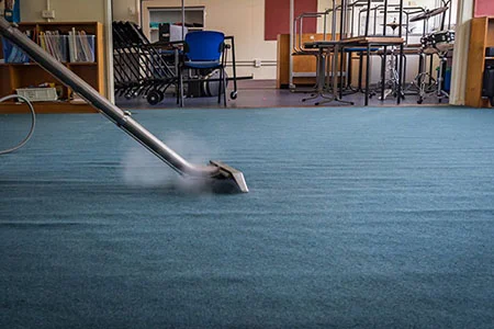 person steam cleaning a carpeted office