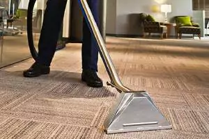 Person cleaning carpet in a commercial space