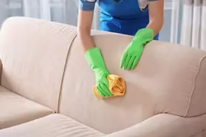 Person removing stain from a sofa